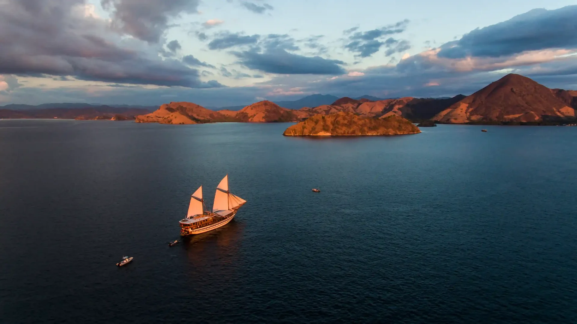 Aerial view of a traditional phinisi sailing between the islands of Komodo National Park