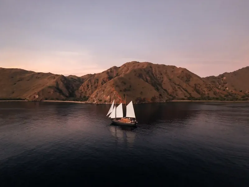 Traditional wooden phinisi at anchor at dusk near Labuan Bajo