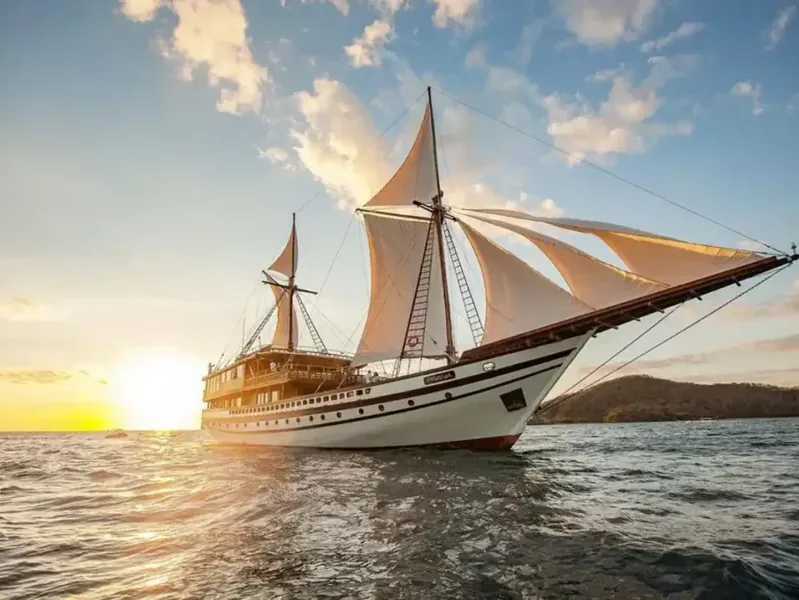 Phinisi sailing under a blue sky in Komodo