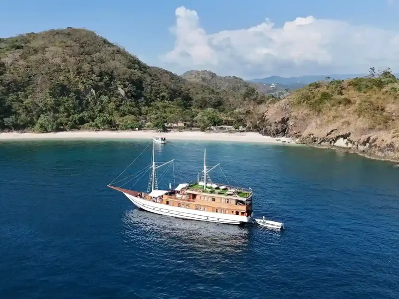 Phinisi sailing past Pink Beach, Komodo