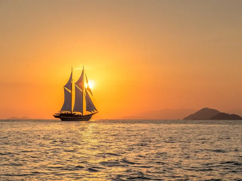 Phinisi sailing into the sunset in Komodo National Park