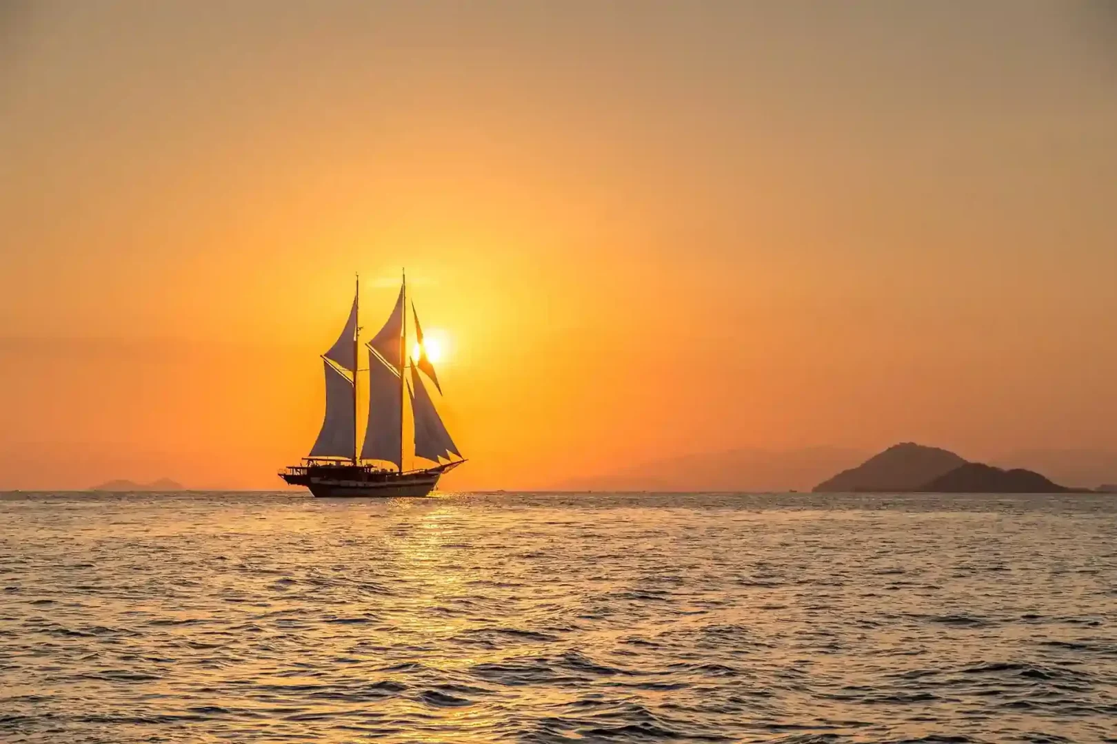 Phinisi on a golden sea at sunset, Komodo