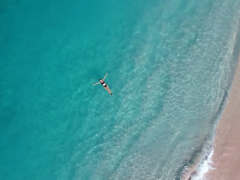 Aerial view of Pink Beach with a snorkeler in the shallows, Komodo
